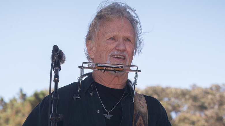 Kris Kristofferson on stage playing guitar