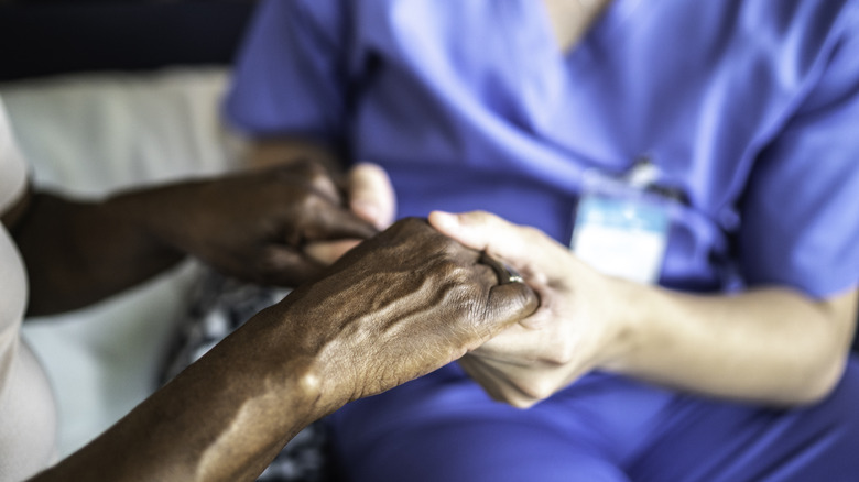 Doctor holding Parkinson's disease patient's hands