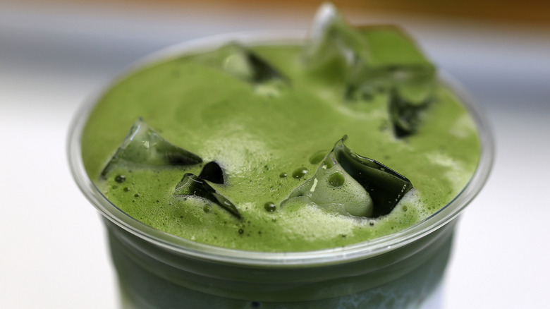 Close up of iced matcha in a plastic cup.