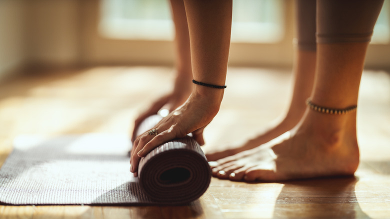 Woman rolling up a yoga mat