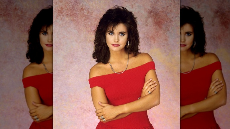 Courteney Cox posing in a red dress