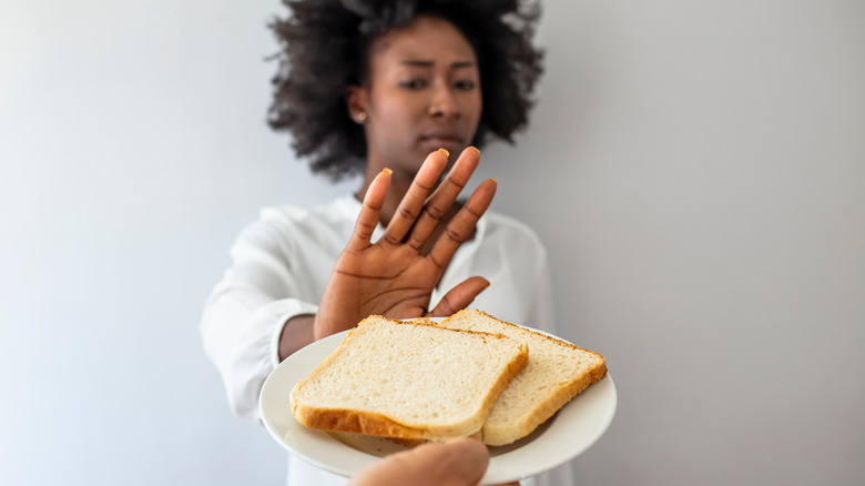 woman turning down plate of bread slices