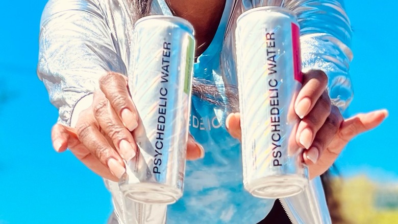 woman holding Psychedelic Water cans