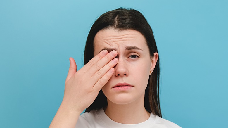 woman with hand over eye