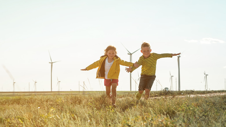 Two children running through a field