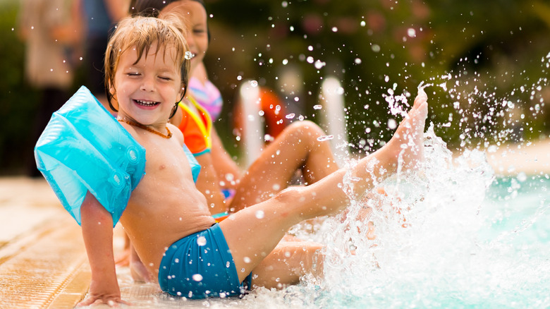 Smiling kids playing in pool