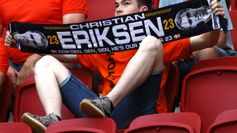 A fan holds up a scarf in support of Eriksen during an earlier Euro 2020 match