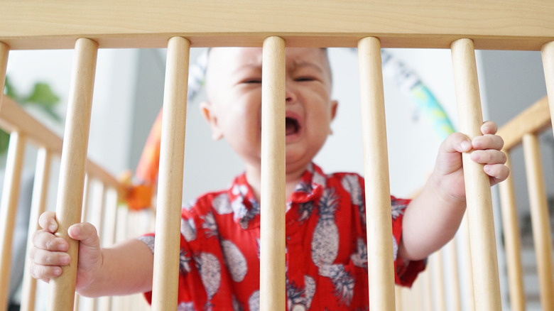 cranky baby in crib
