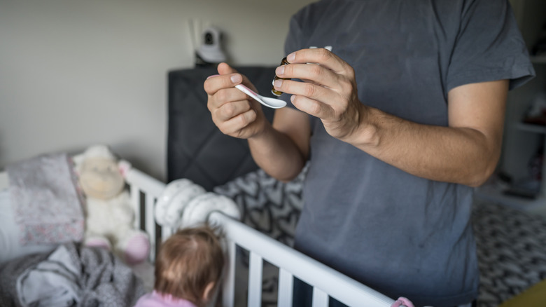 dad giving probiotics to baby