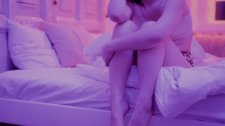 woman sitting up in bed awake anxious