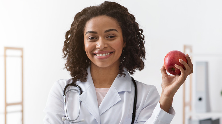 Doctor holding up apple