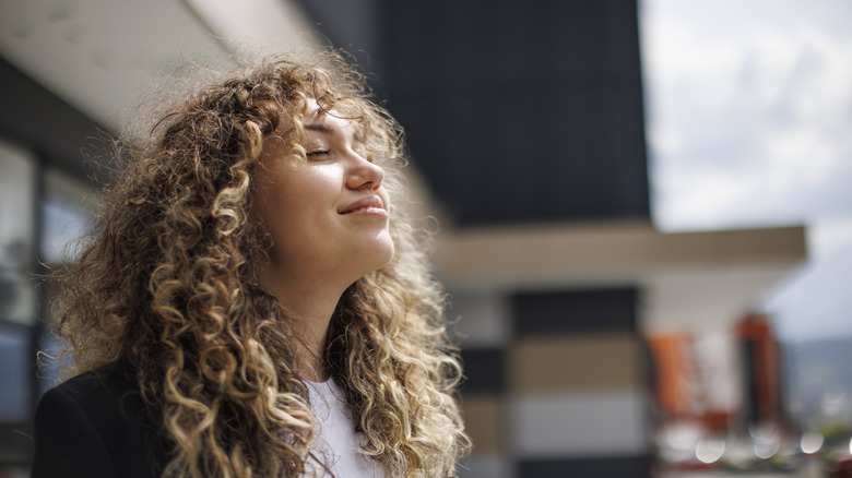 young smiling business woman outside with eyes closed