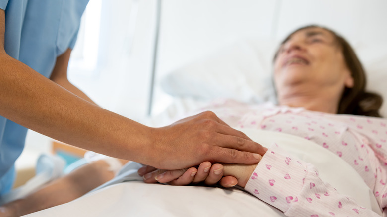 Someone at the end of life being comforted by nurse