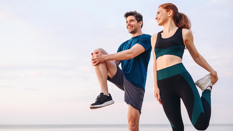 Man and woman stretching on the beach