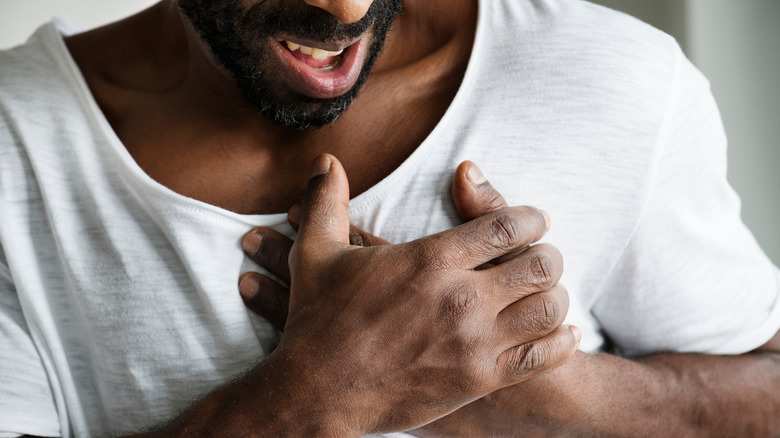 man holding chest