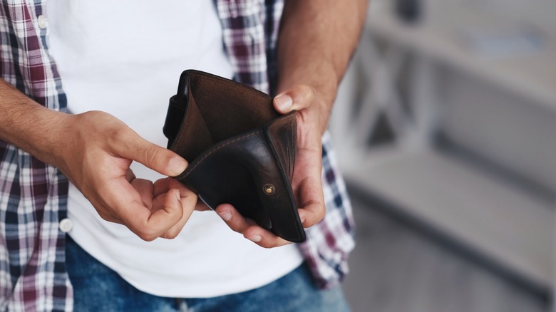 Man opening empty wallet
