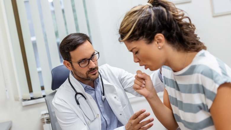 woman coughing at doctor's surgery