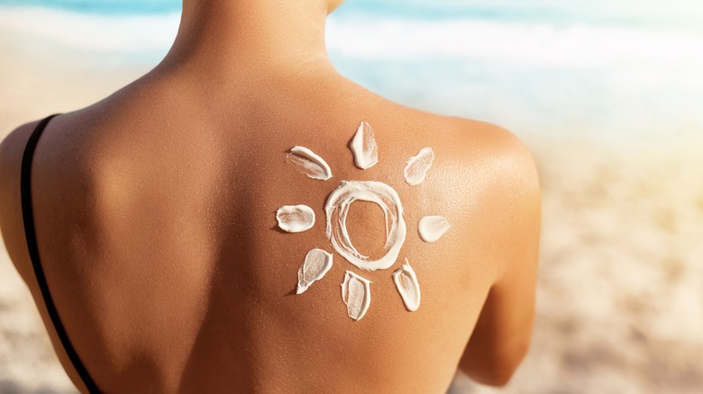 A woman with sunscreen in the shape of a sun on her back