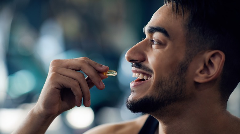 happy handsome man taking a pill