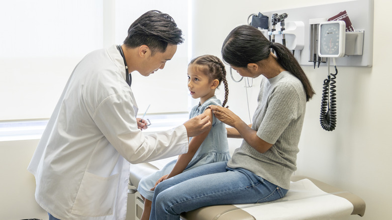 young girl with her mother getting a vaccine