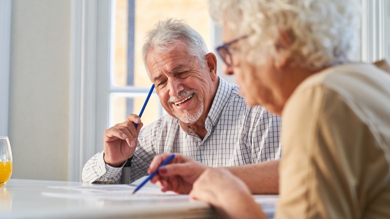 older man and a woman doing puzzles