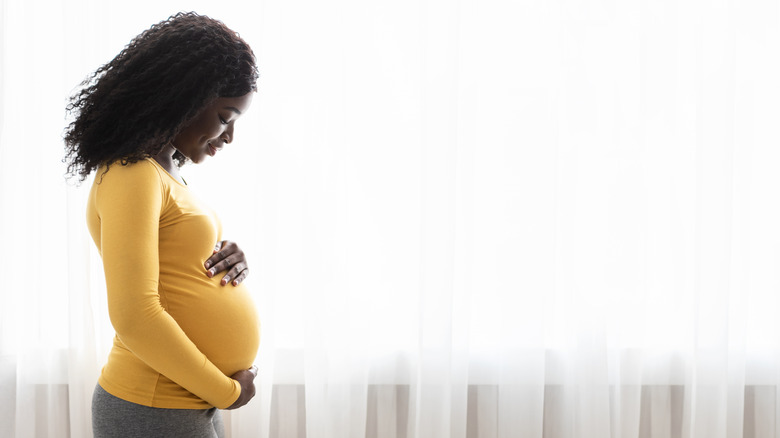 Pregnant woman holding stomach