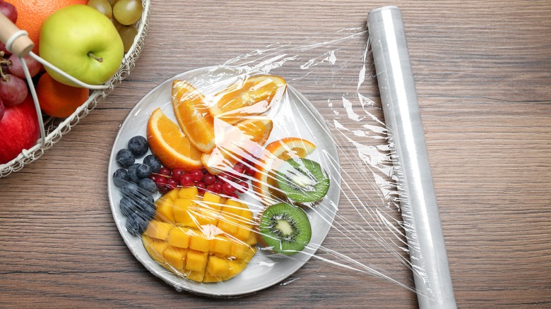 Plate of food covered with plastic wrap
