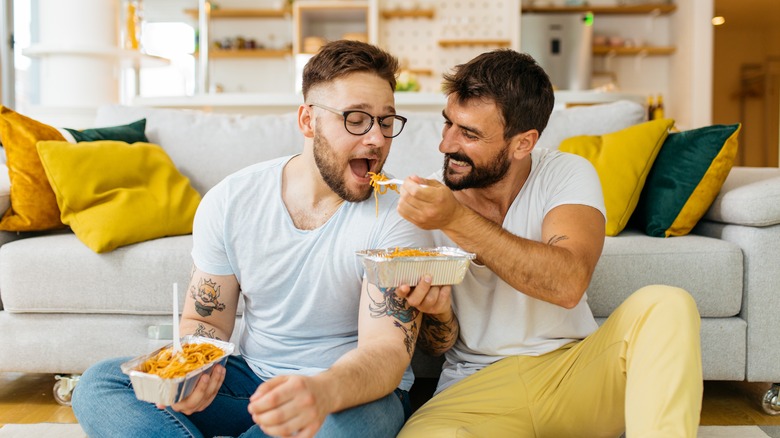 a couple eating pasta together 