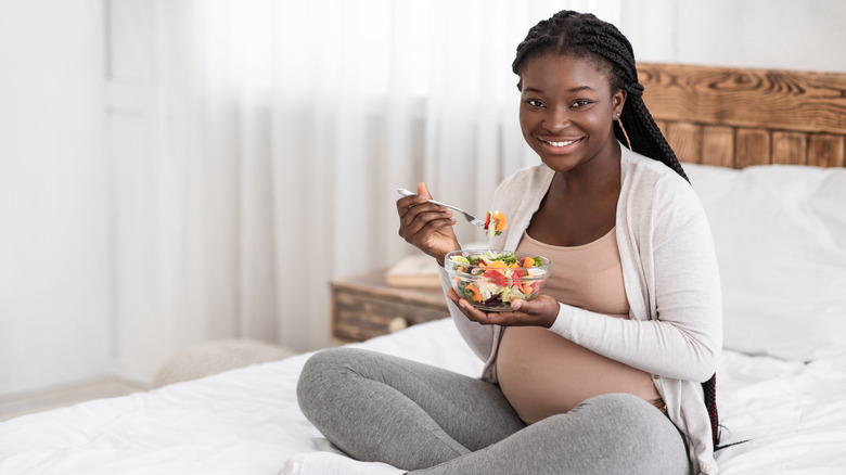 pregnant woman eating vegetable salad