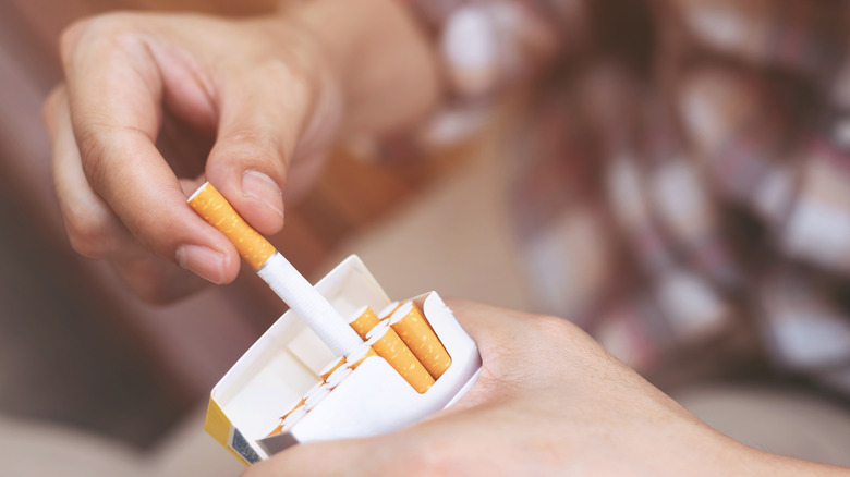 hand holding pack of cigarettes