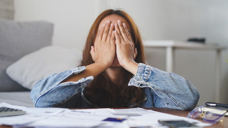 Woman expressing stress from paperwork