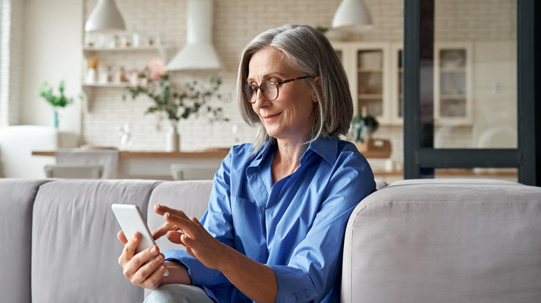 elderly woman using smart phone on the couch