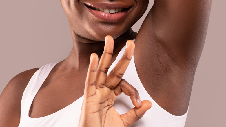 Black woman giving 'ok' sign to armpit