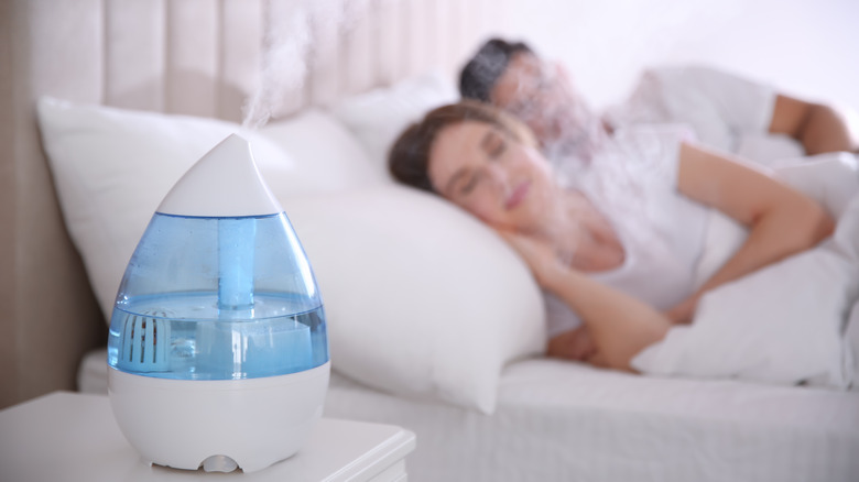 A couple sleeps with a humidifier in their room