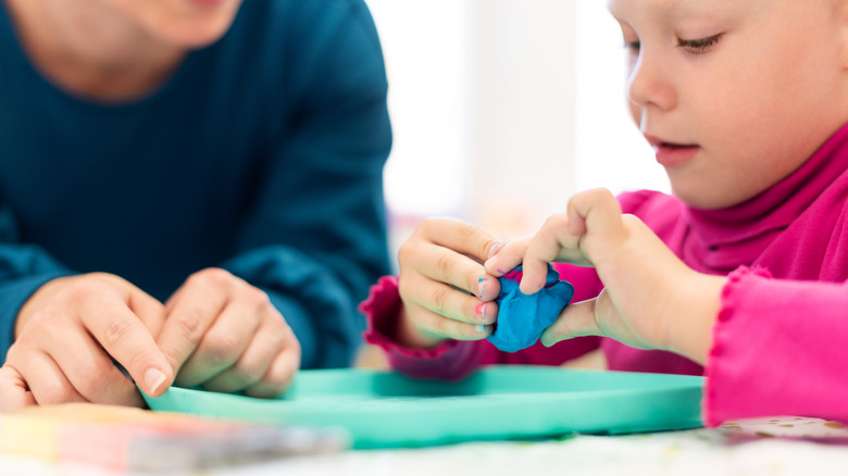 Young child playing with clay