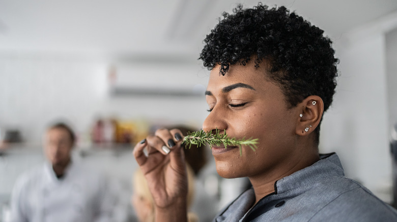 Chef sniffing fresh herbs