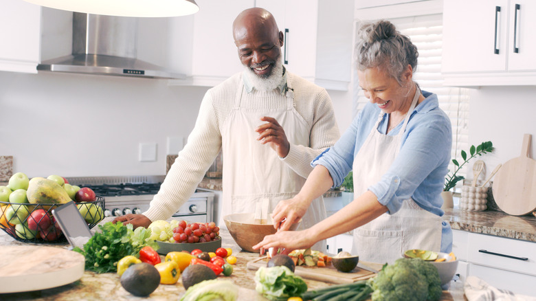 older couple fixing healthy meal