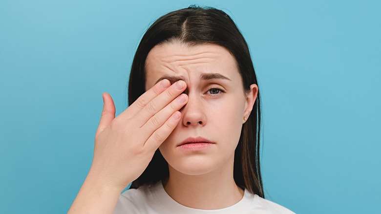 woman rubbing irritated eyes