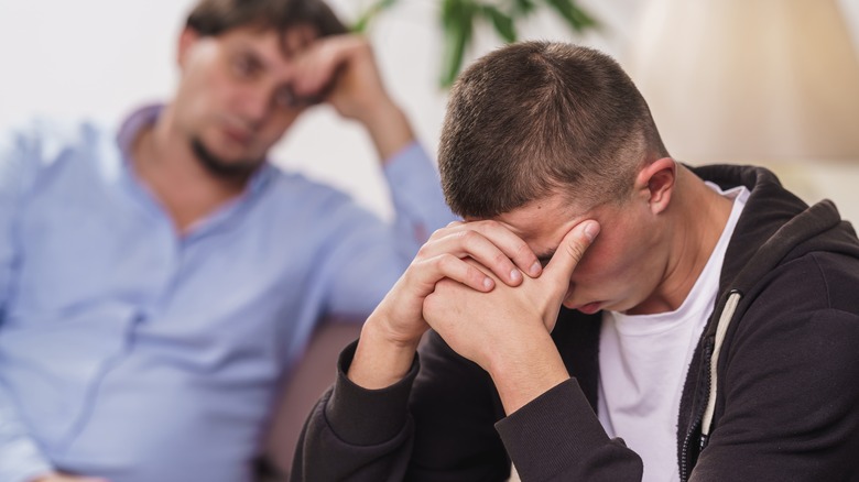 Young adults hugging facing away