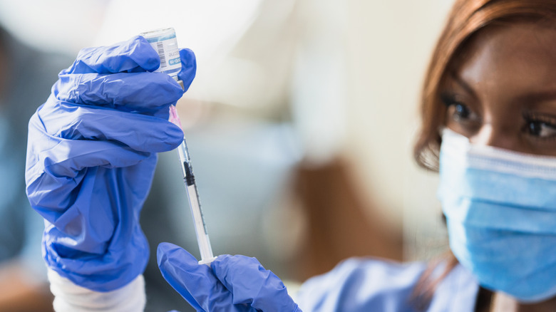 Doctor holding vaccine syringe