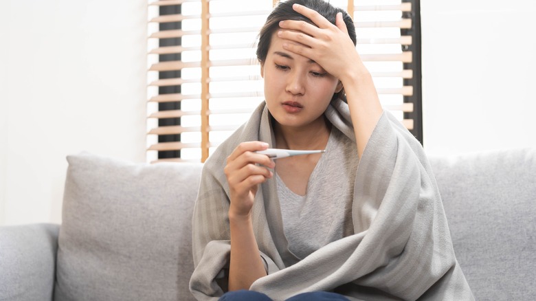 woman looking at thermometer 
