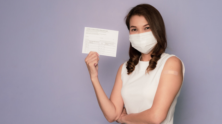 Asian woman holding vaccination card