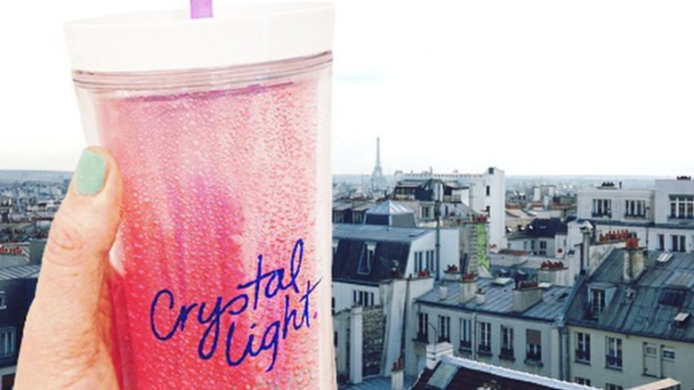 Woman's hand holding up a crystal light with city background 