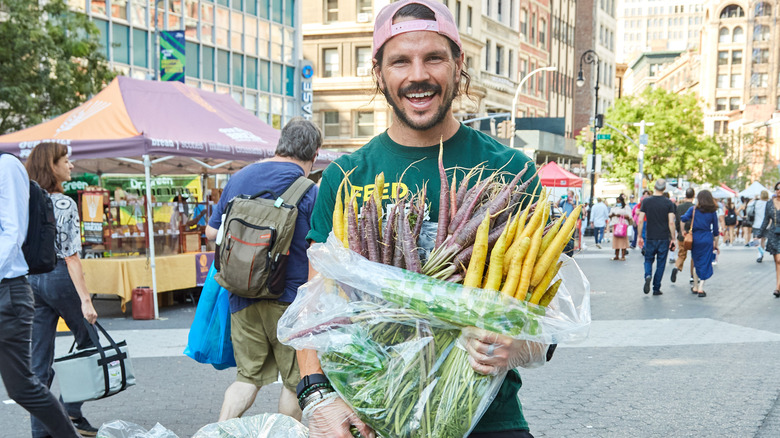 Dan Churchill smiling holding bag of carrots
