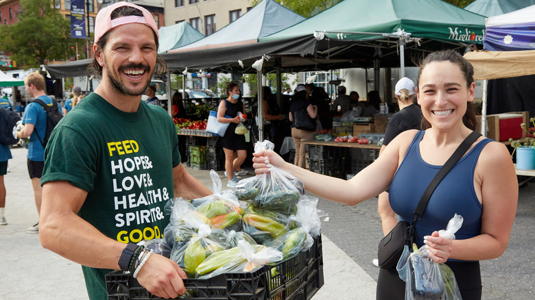 Dan Churchill smiling giving peppers to woman
