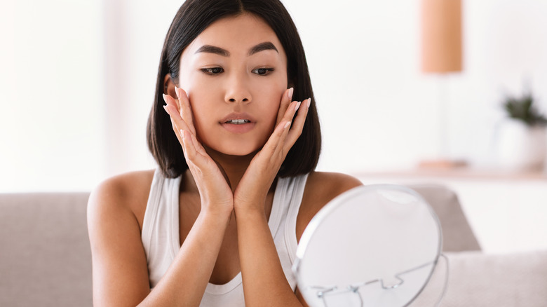 woman looking at self in mirror