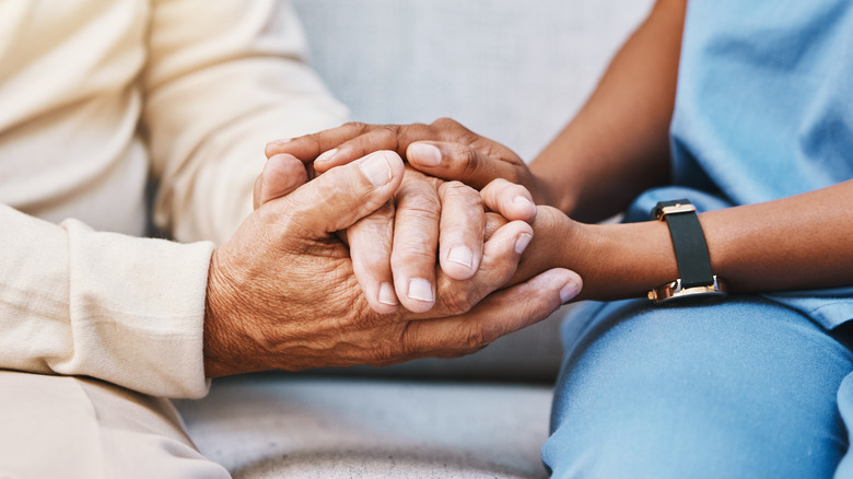 healthcare worker holding patient's hands