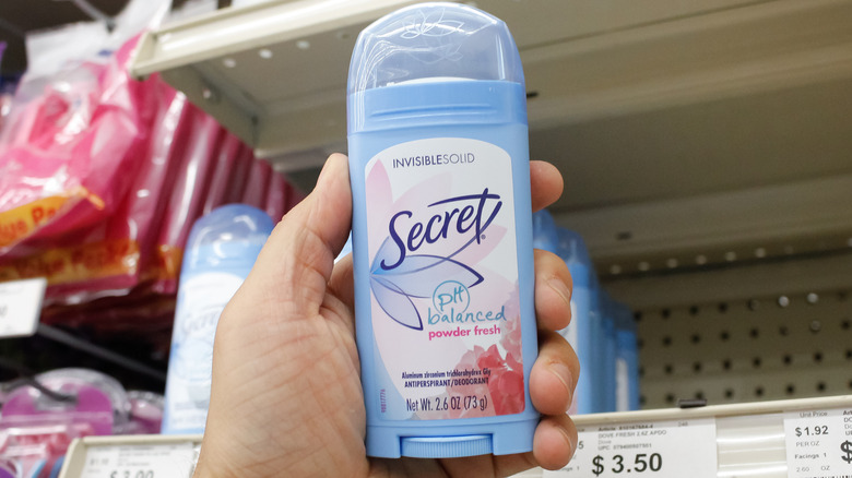 Hand holding Secret deodorant stick