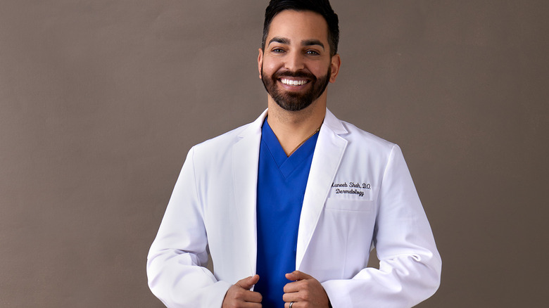 Dr. Shah in his lab coat smiling