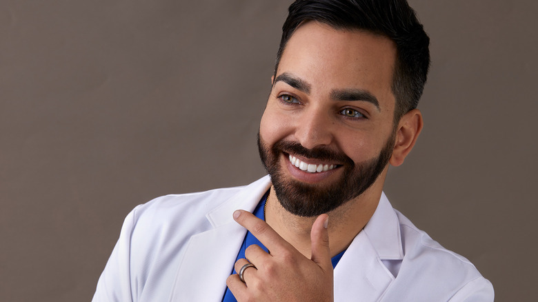 Dr. Muneeb Shah smiling with his hand under his chin